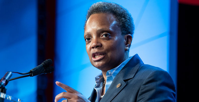 Chicago Mayor Lori Lightfoot speaks in front of a blue background.