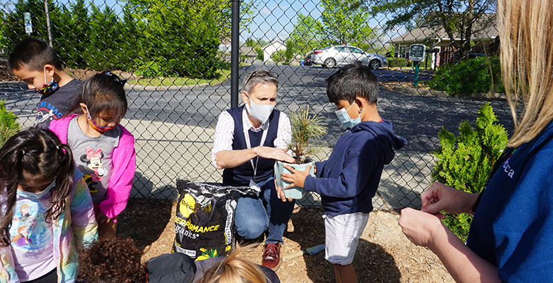 A photo of Head Start staff and children at the King Creek Children’s Center in Hendersonville, North Carolina, planting trees during an Arbor Day event last year
