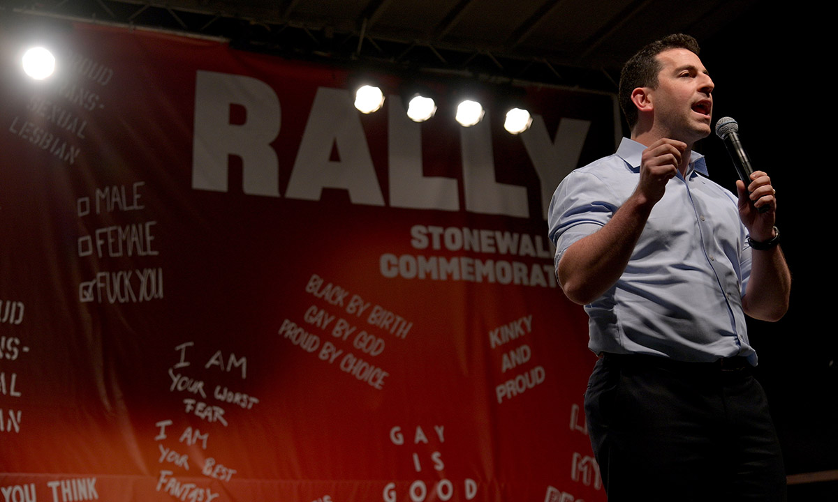 Amit Paley stands speaking and holding a microphone