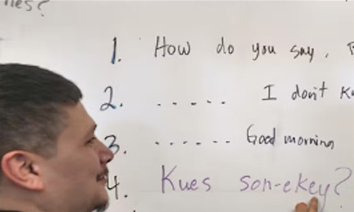 A teacher writes on a whiteboard.