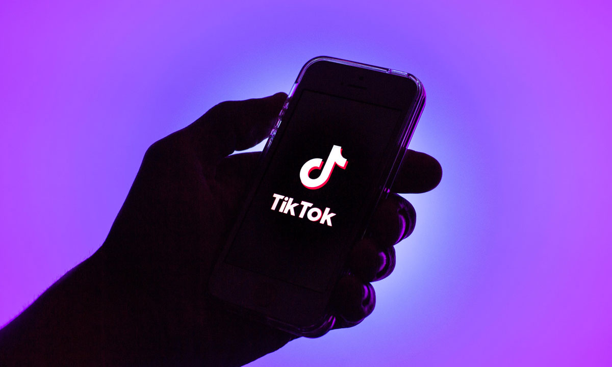 a phone holding a phone opening up the TikTok application