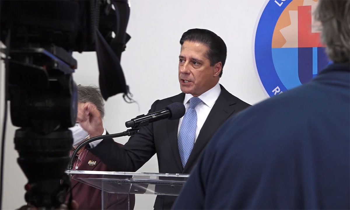 A photo of Alberto Carvalho speaking to cameras in front of an LAUSD logo
