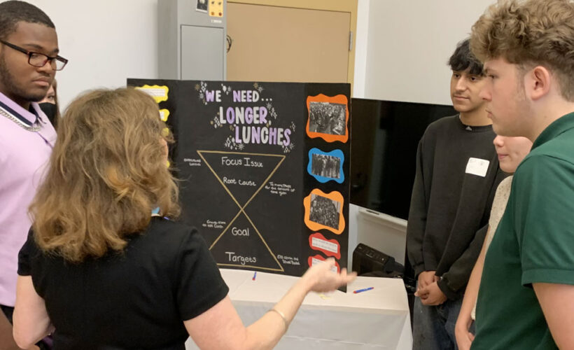A student explains a project with the title "We need longer lunches"