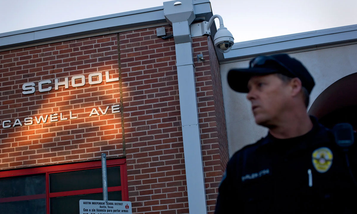 This photo shows a police officer in front of a school building