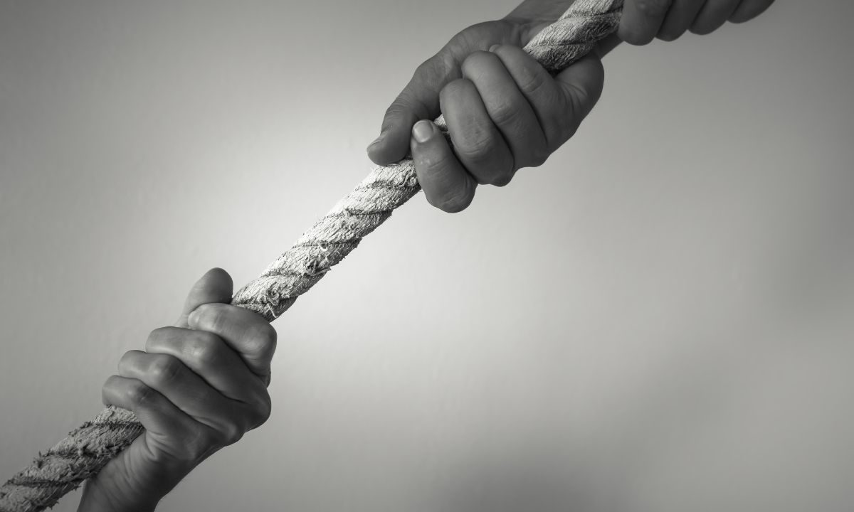 A black and white photo of someone rescuing another person with a rope