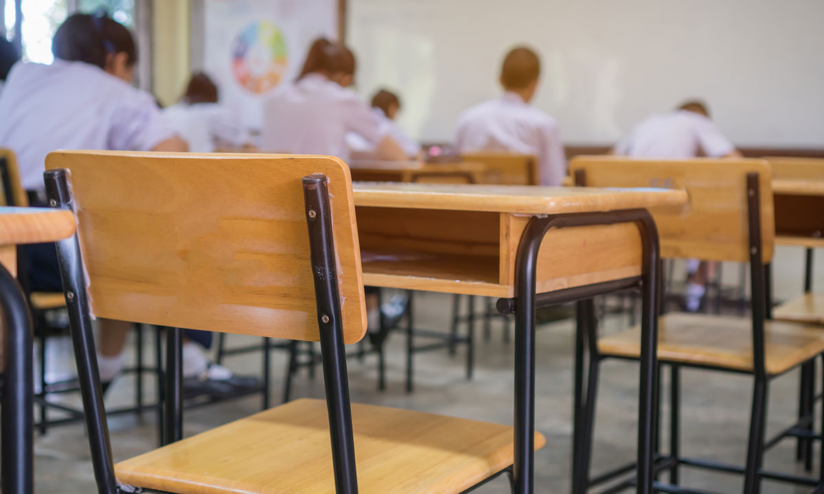 This is a photo of an empty desk in a classroom.