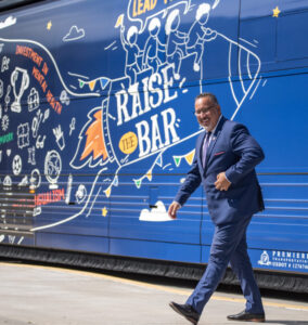 This is a photo of Migues Cardona walking off the "Raise the Bar" tour bus. 