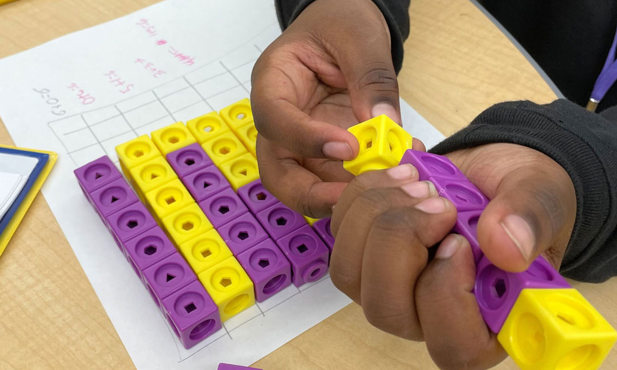 This is a photo of a child holding math connecting cubes.