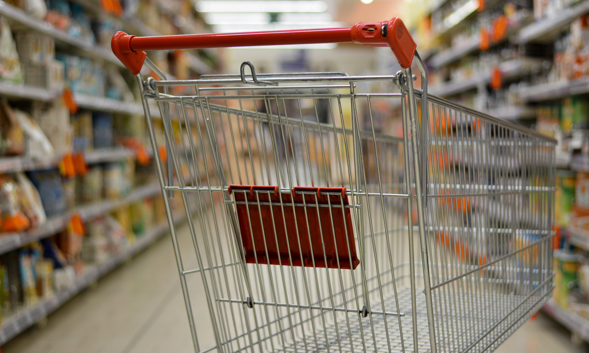 an empty grocery cart in the middle of a grocery store