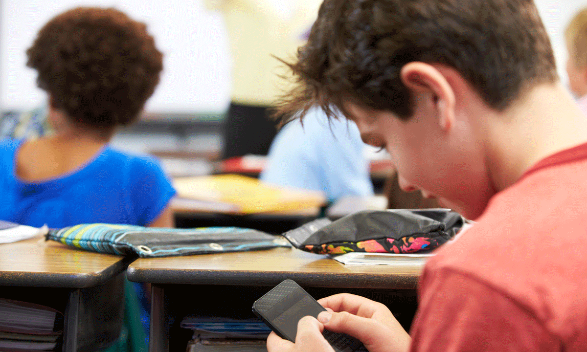 a photo of a student using a smartphone at their desk