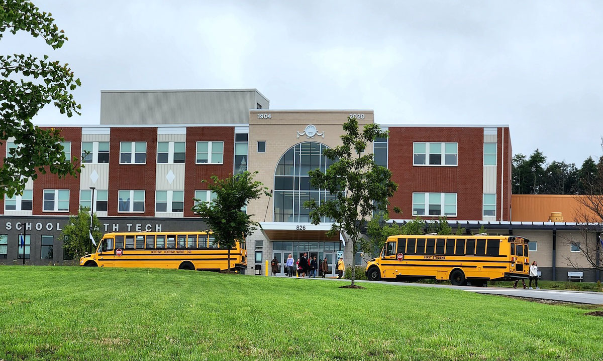This is a photo of school buses in front of a school.