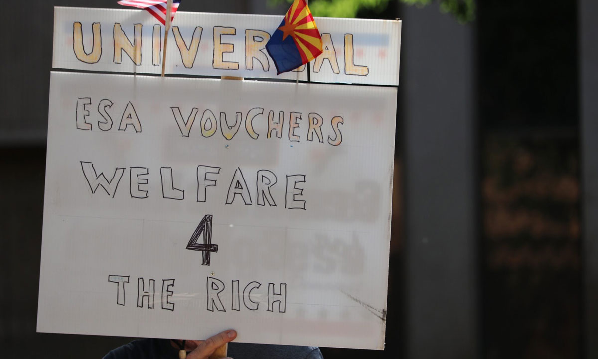 This is a photo of a sign that says "Universal ESA Vouchers Welfare 4 the Rich"