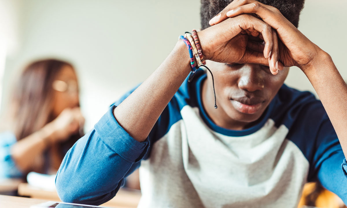 This is a photo of a stressed student at his desk.