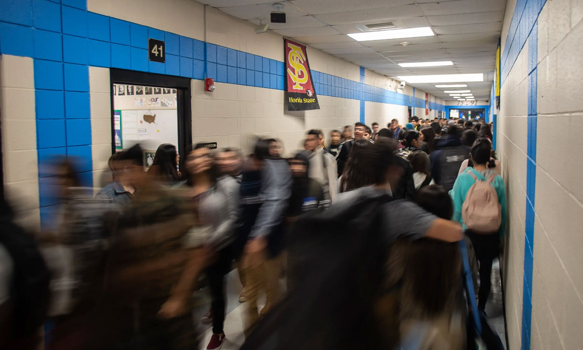 This is a blurred photo of students walking in a school hallway.