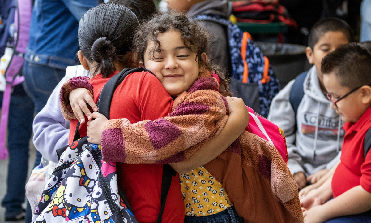 a news photo of two students hugging