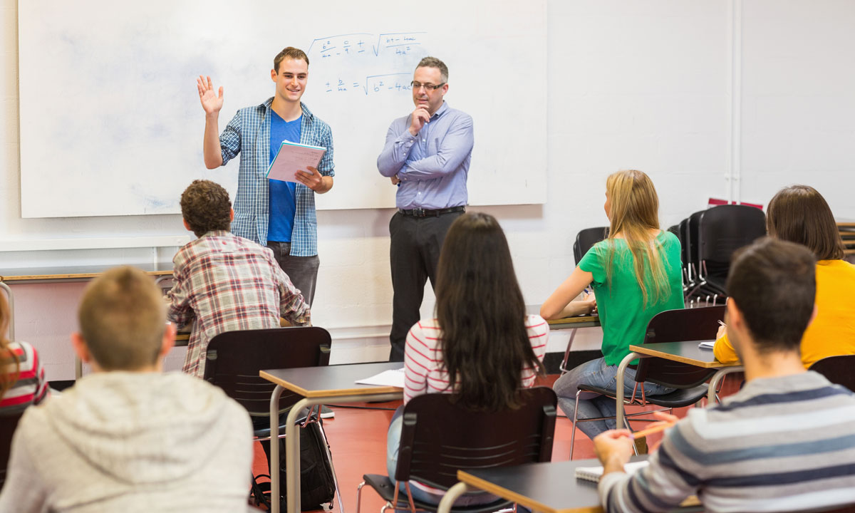 This is a photo of two teachers in front of a classroom.