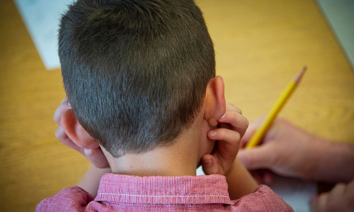 This is a photo of a student working on their writing skills with a teacher.