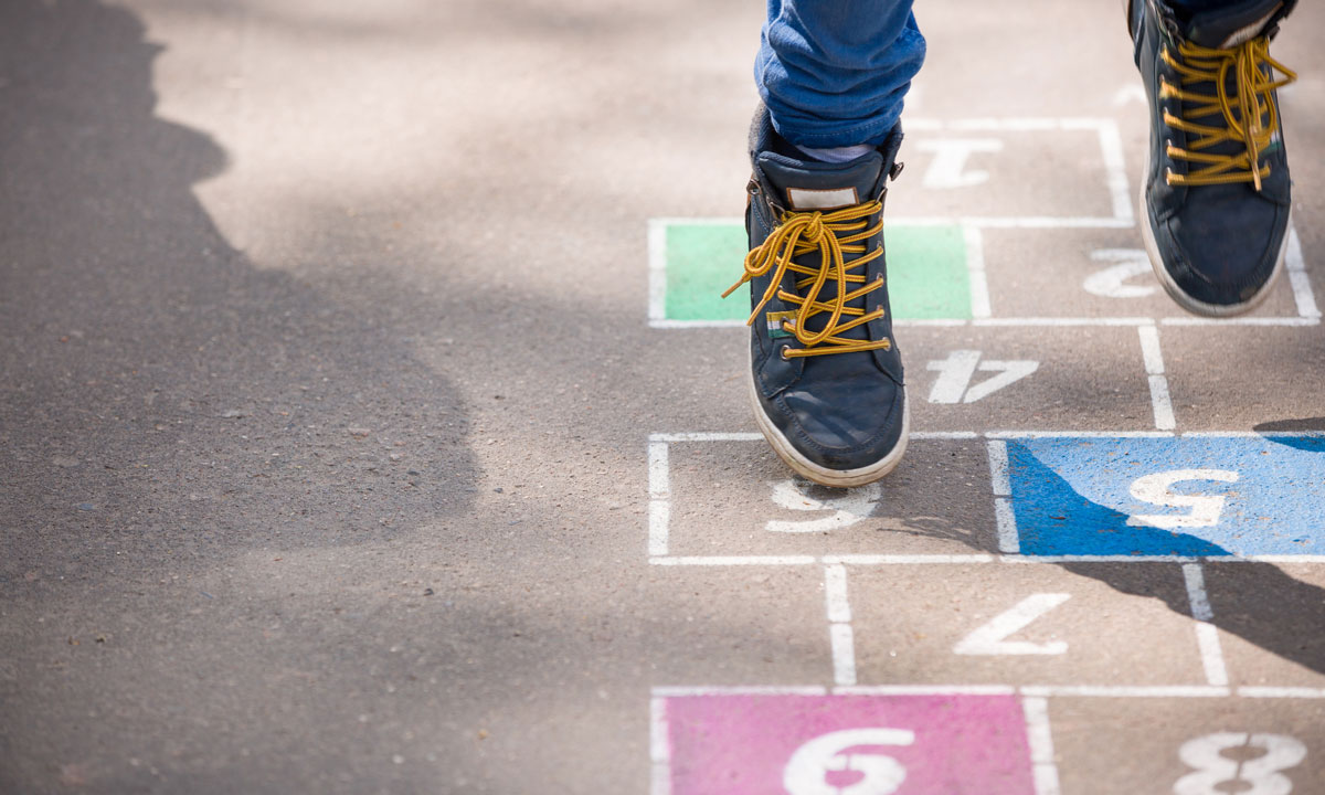 This is a photo of a kid playing hopscotch.