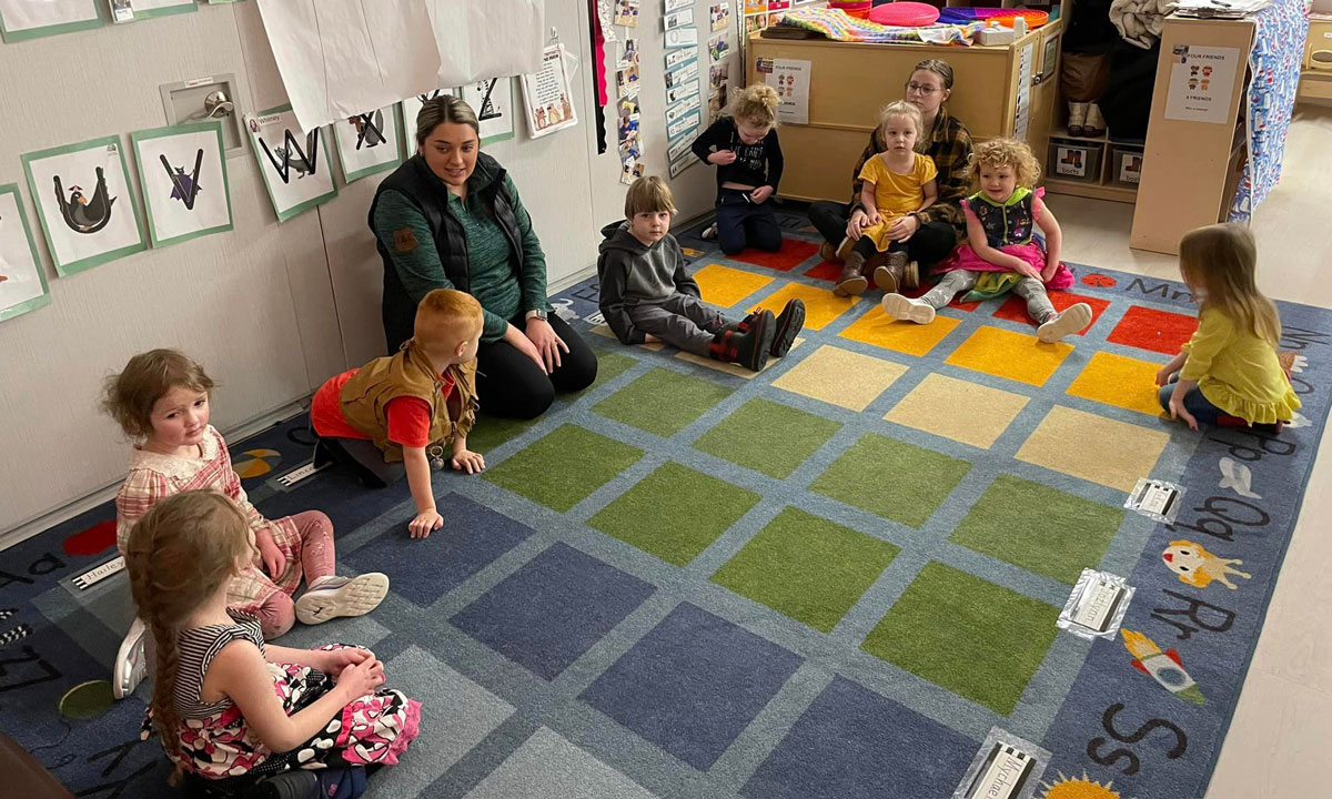 This is a phofo of Palmer Head Start teacher Moriah Morris sitting with children.