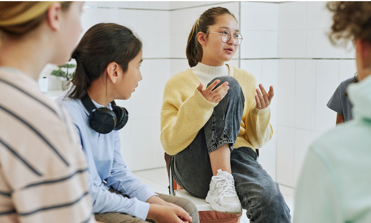 This is a photo of young girls talking in a circle.