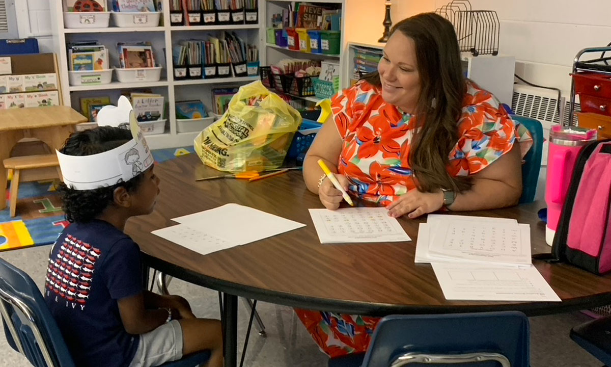 This is a photo of teacher working with a studen one-on-one at a desk.