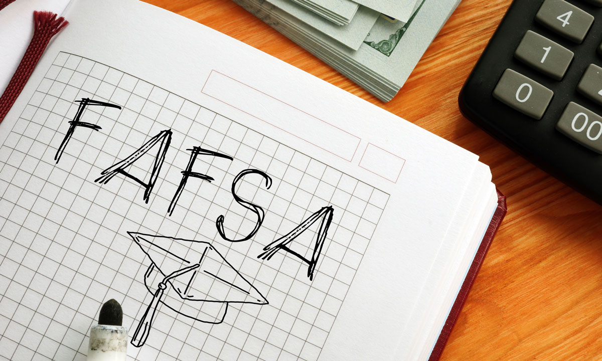 This is a photo of a notebook with "FAFSA" written on it and a drawn graduation cap.