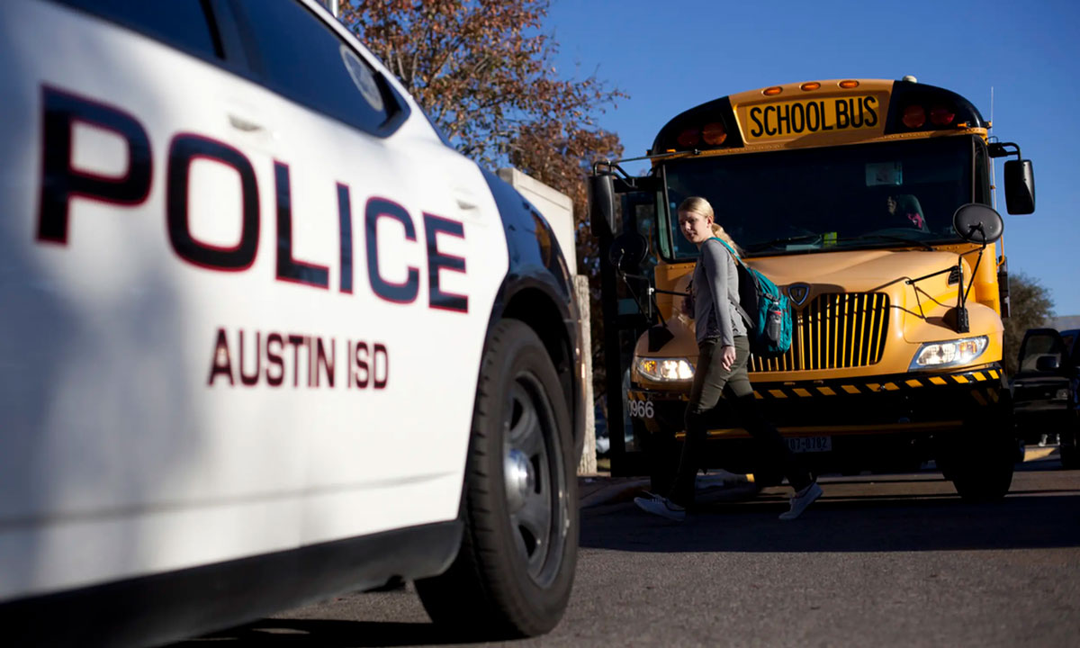This is a photo of a police car parked in front of a school bus.
