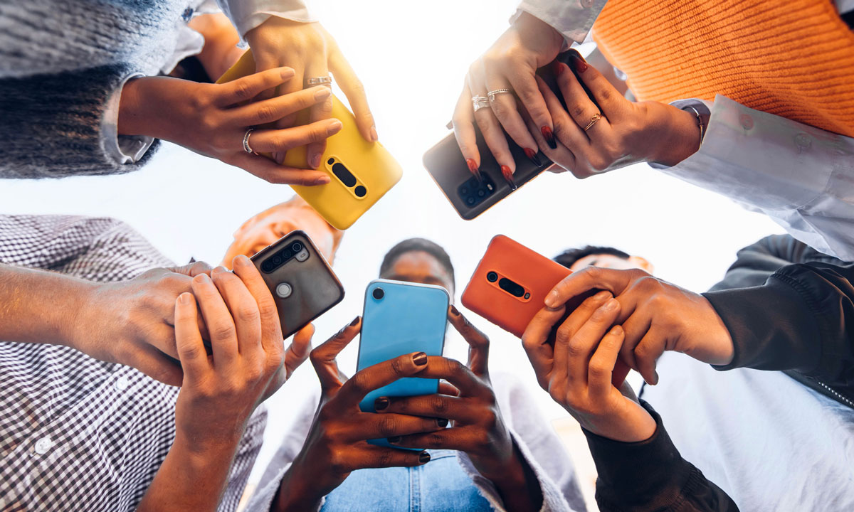 This is a photo of teens in a circle on their cellphones.