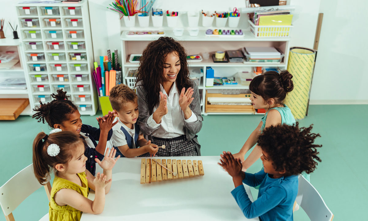 This is photo of a teacher with a small diverse group of students.