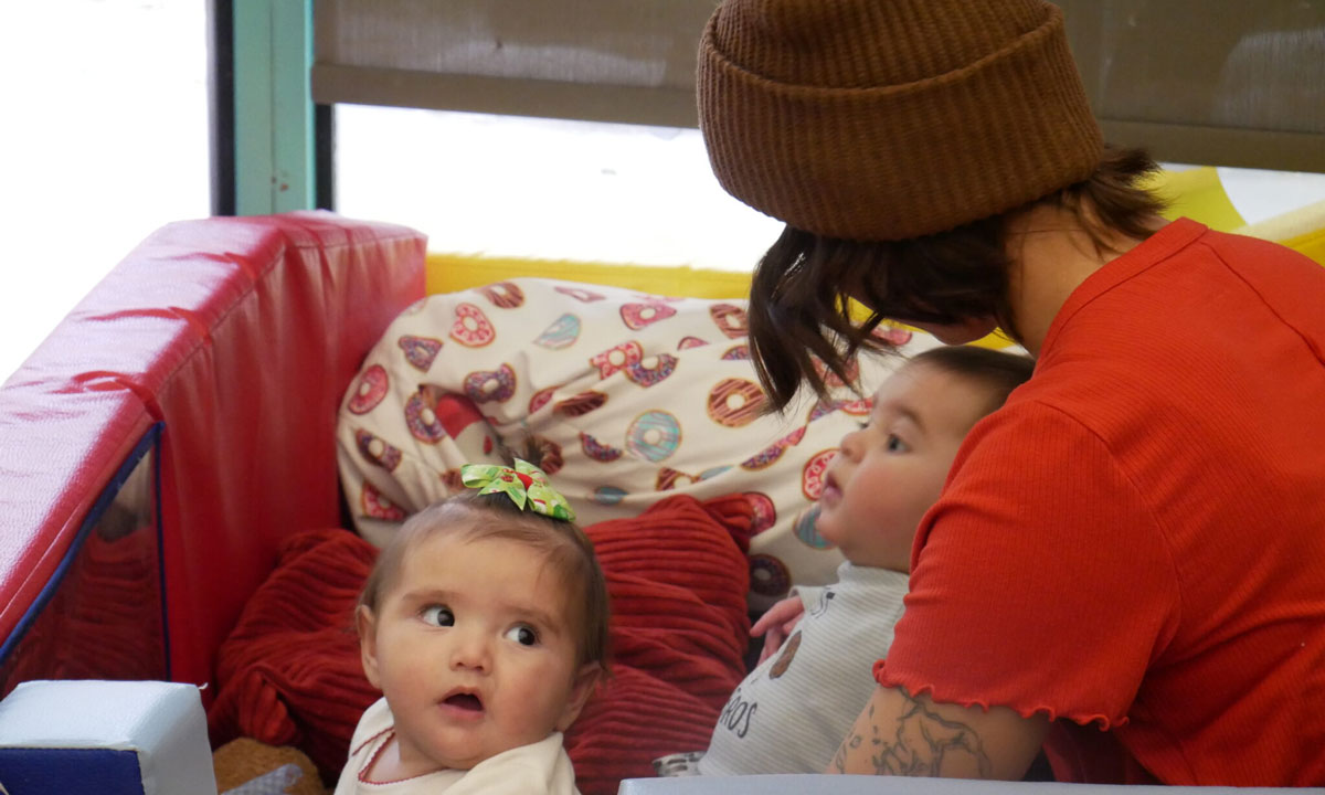 This is a photo of a woman watching two babies.