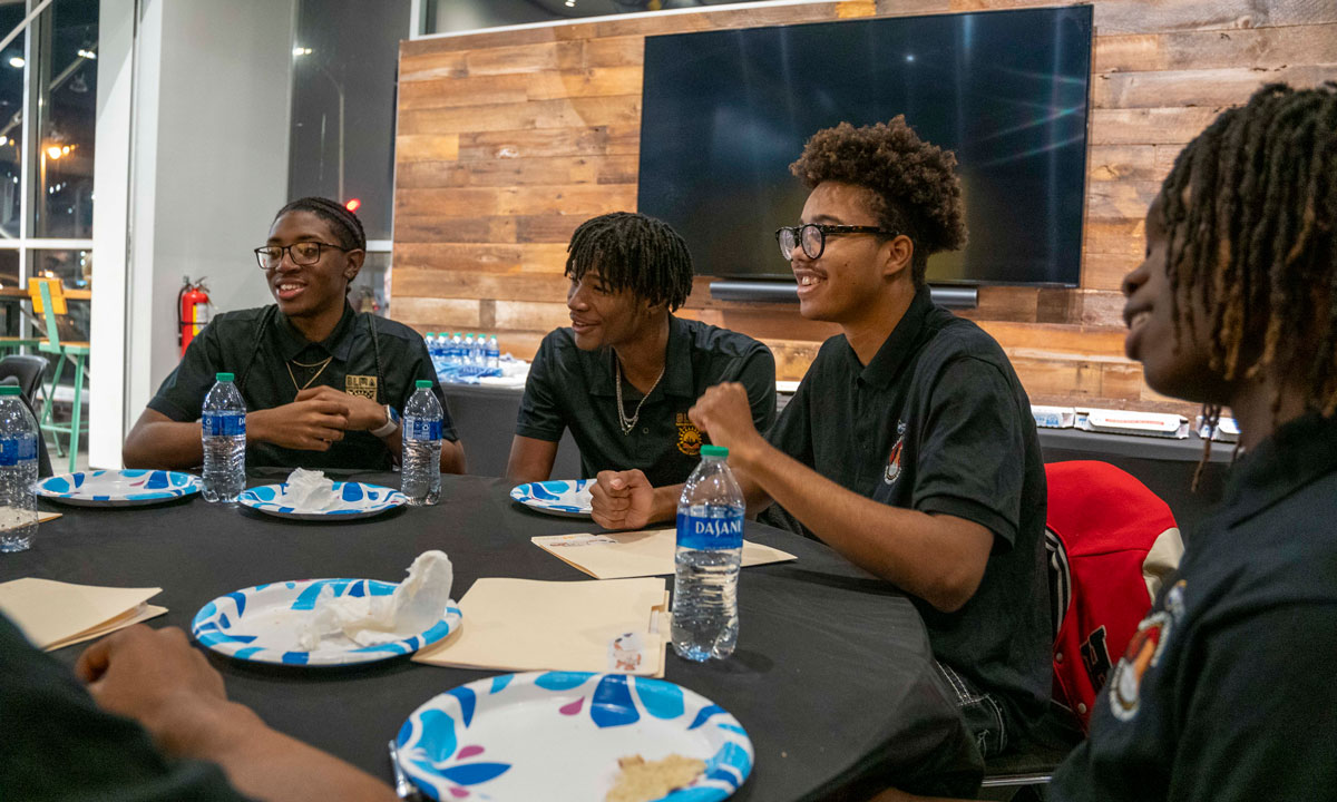 This is a photo of Black male Wisconsin students at a roundtable conversation.