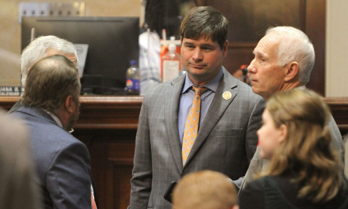 This is a photo of Rep. Patrick Haddon talking with colleagues in the House chamber.