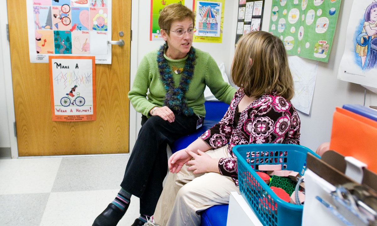 This is a photo of a school nurse talking to a student.