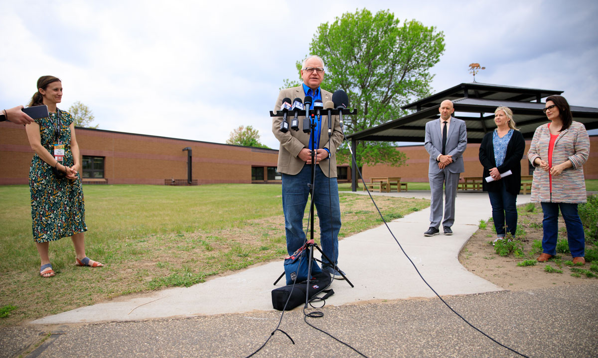 This is a photo of Gov. Walz speaking at a podium outside.