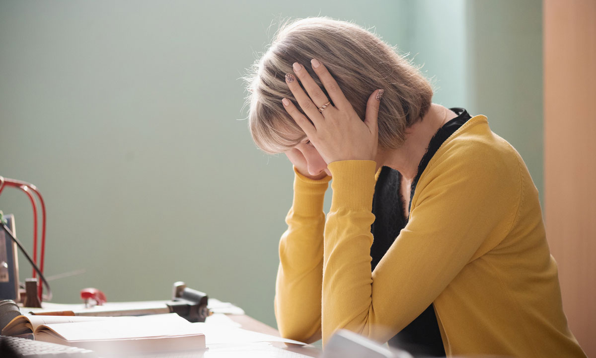 This is a photo of a teacher stressed at her desk.