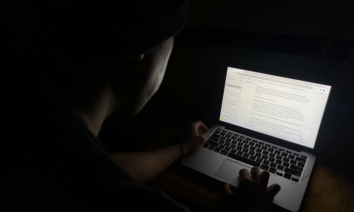 This is a photo of someone typing on a Macbook in the dark.