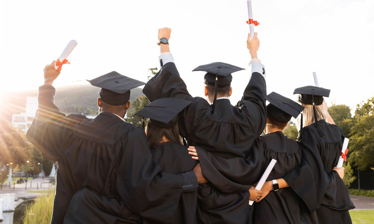 This is a photo of a group of students in cap and gowns facing away from the camera.