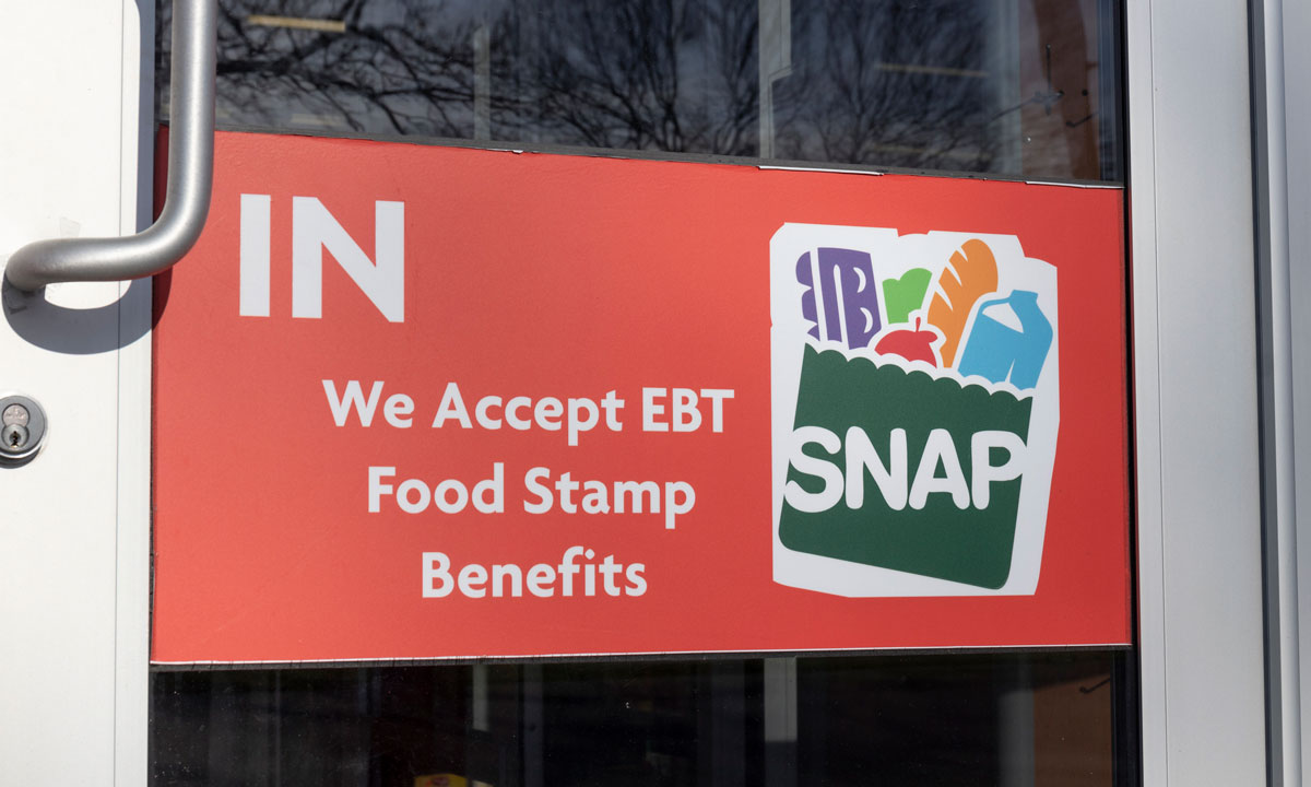 This is a photo of a sign on a business that says "We accept EBT food stamp benefits"