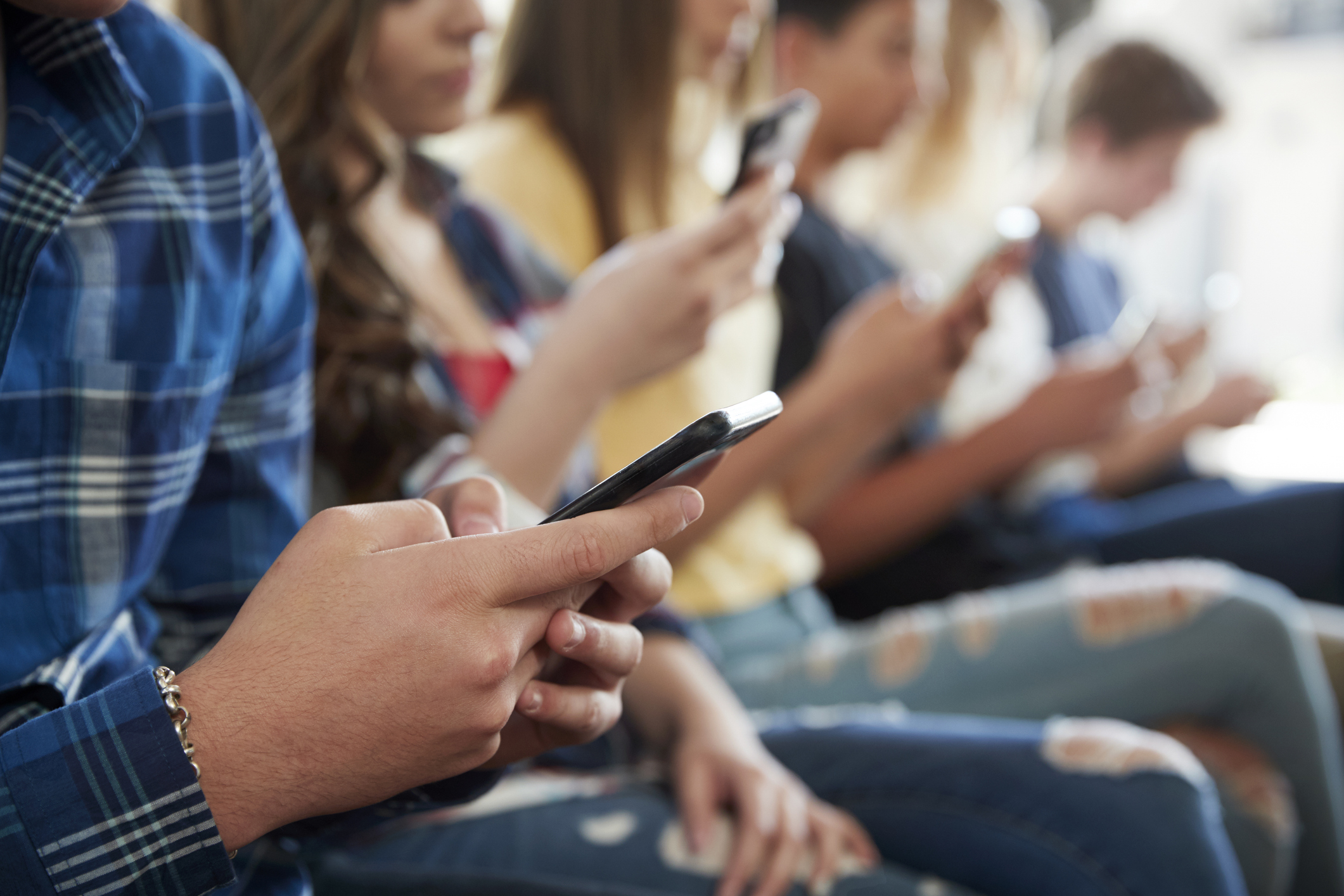 This is a photo of teens on their cellphones.